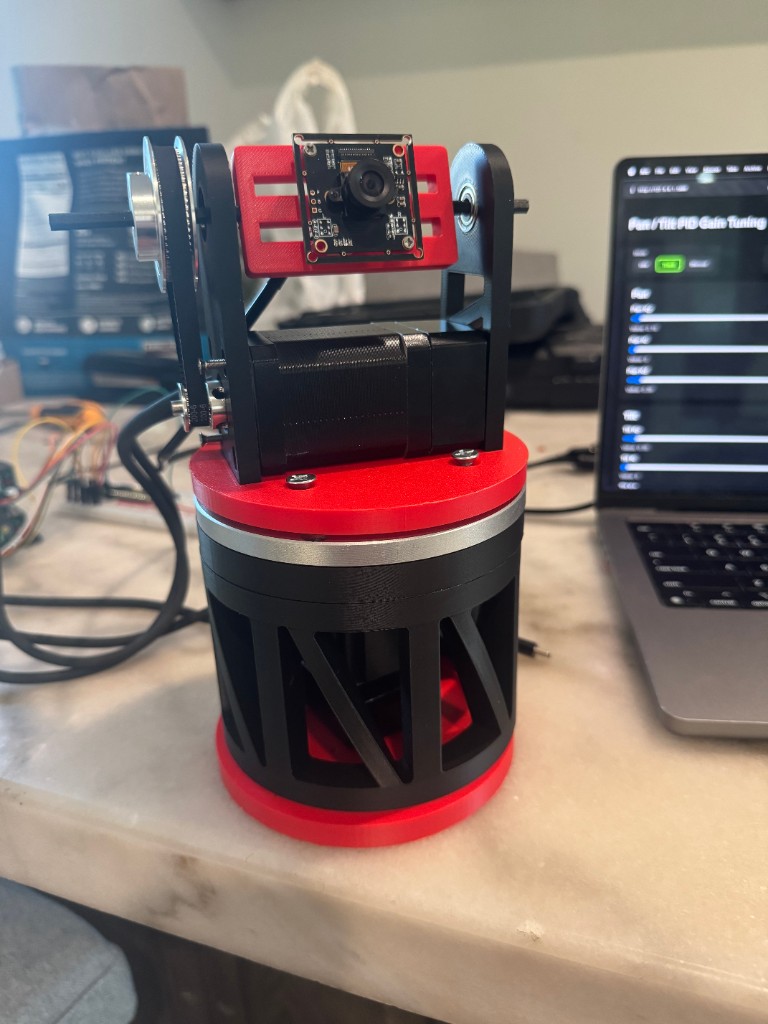 Assembled red-and-black pan/tilt turret with camera and PID tuning dashboard on a laptop